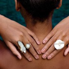Hands showing rings behind a head.